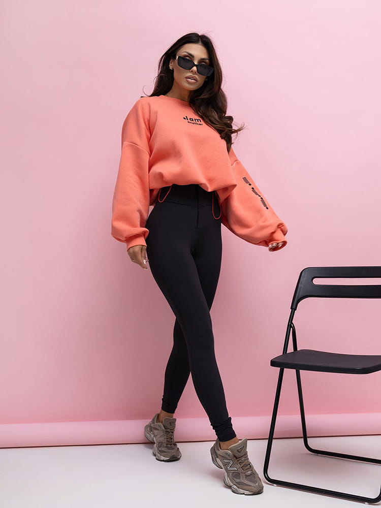 damski komplet pomarańczowa bluza oversize i czarne legginsy z wysokim stanem oraz zamkiem z przodu