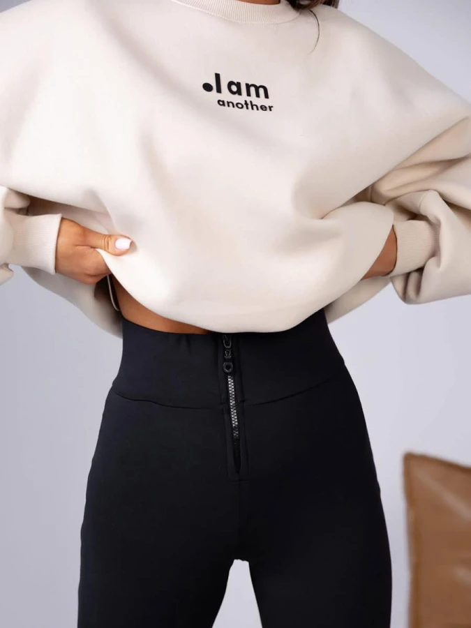 damski komplet beżowa bluza oversize i czarne legginsy z wysokim stanem oraz zamkiem z przodu