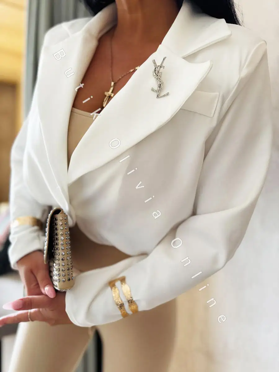 elegancka krótka marynarka jak bomerka z broszką oraz poduszkami na ramionach