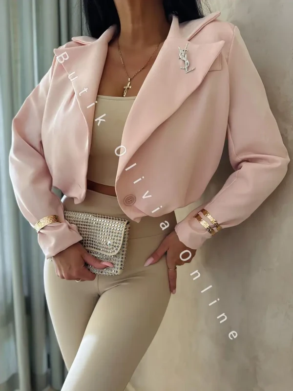 elegancka pudrowo różowa krótka marynarka jak bomerka z broszką oraz poduszkami na ramionach