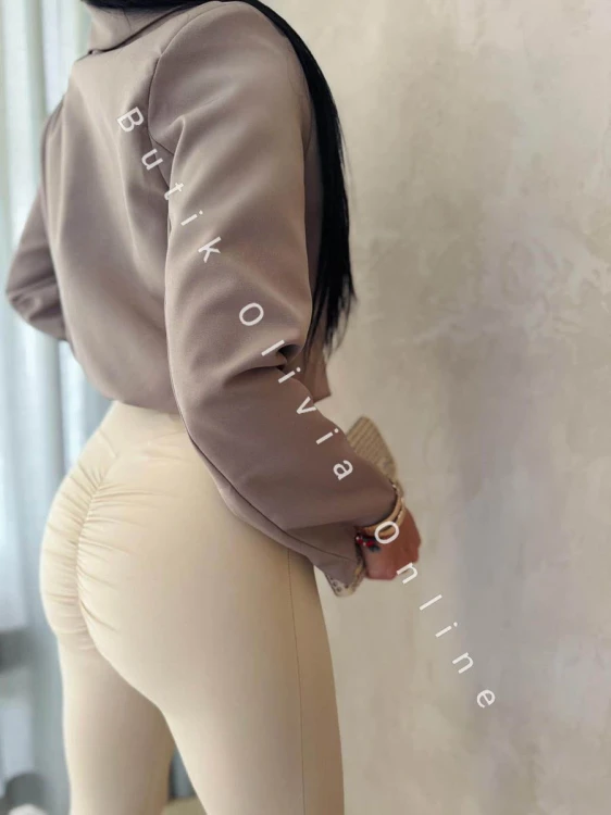 elegancka beżowa  krótka marynarka jak bomerka z broszką oraz poduszkami na ramionach