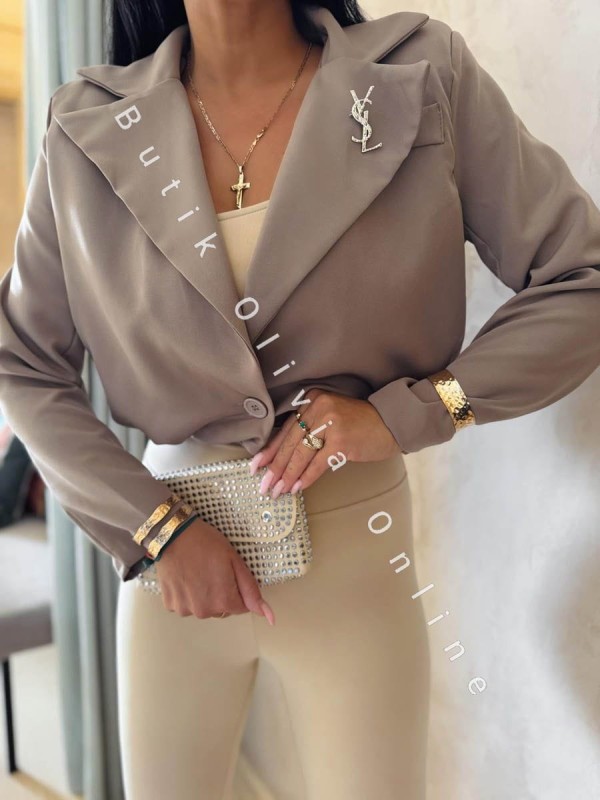 elegancka beżowa  krótka marynarka jak bomerka z broszką oraz poduszkami na ramionach