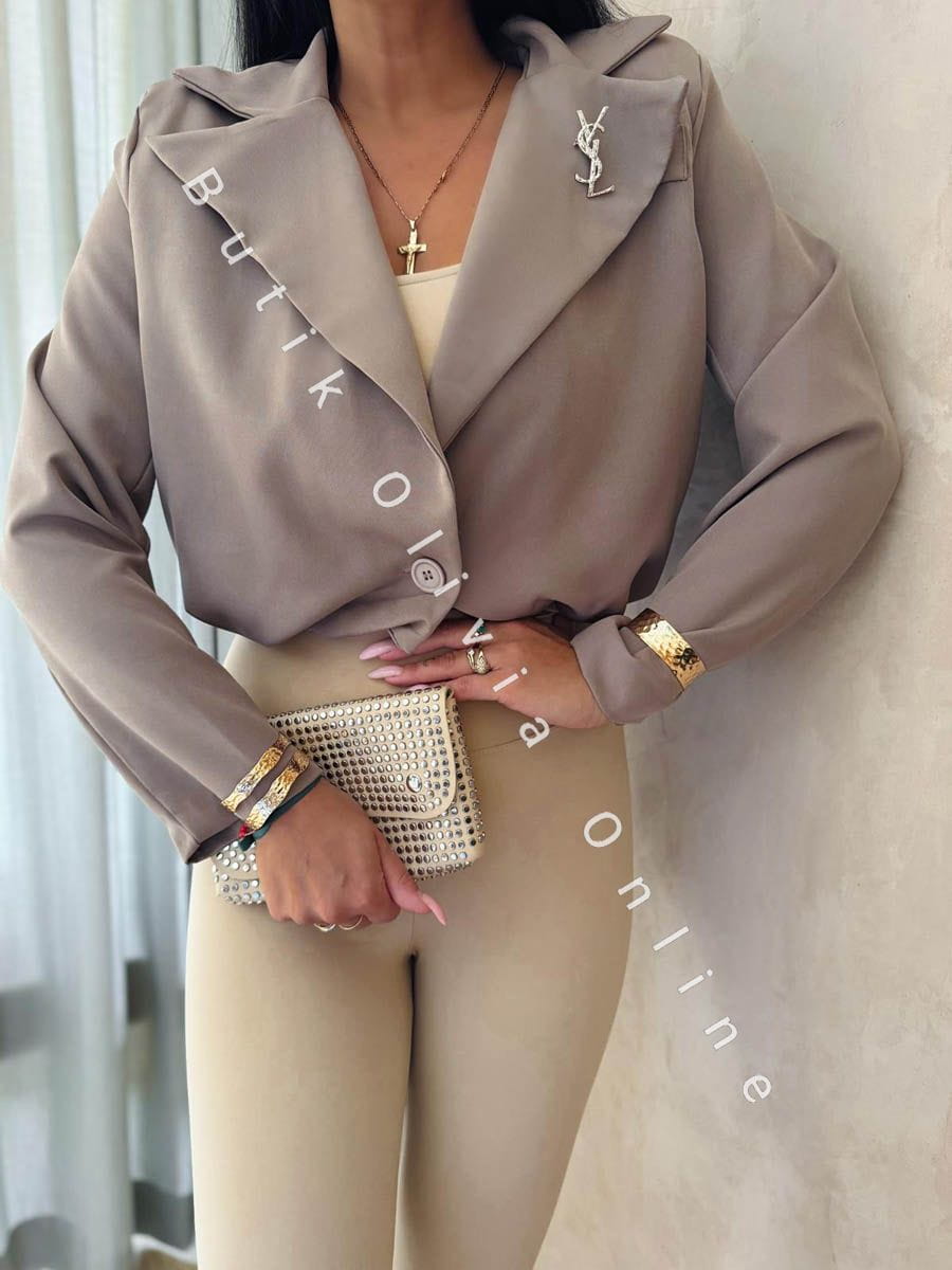 elegancka beżowa  krótka marynarka jak bomerka z broszką oraz poduszkami na ramionach