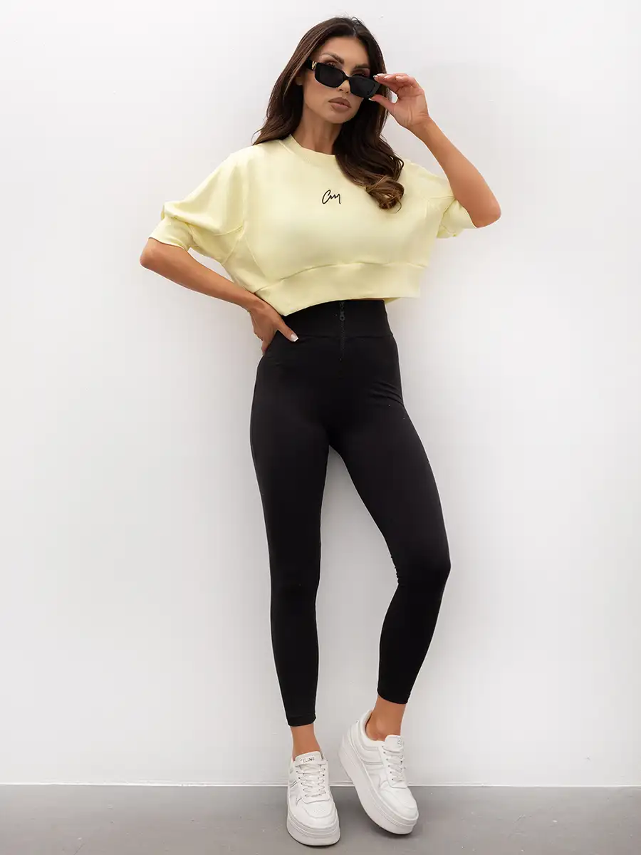 komplet cytrynowa krótka bluza crop top z czarnymi modelującymi legginsami z wysokim stanem i zamkiem z przodu