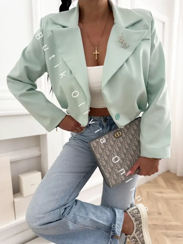 elegancka miętowa krótka marynarka jak bomberka z broszką oraz poduszkami na ramionach